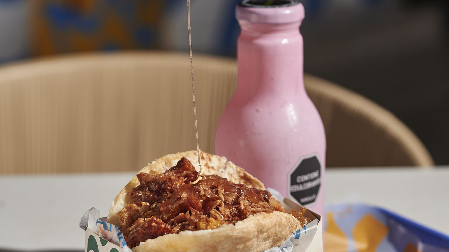 Arepa Amá en su caja junto a un té Hatsu en el local