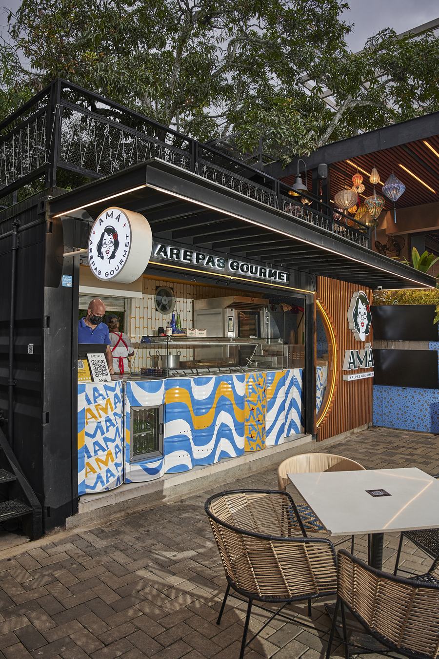 Fachada del local de Amá Arepas Gourmet en el CC Marbella, con el azulejo de ondas de la marca